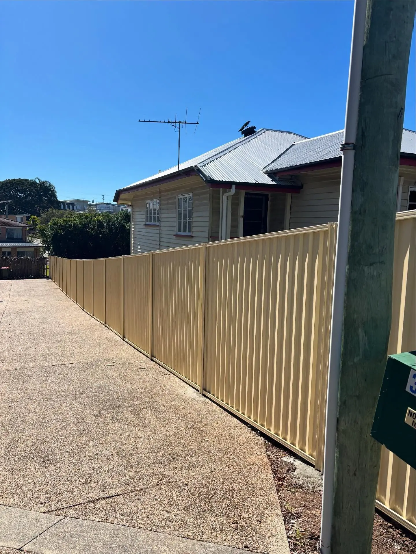 Primrose Colorbond fence running along a driveway